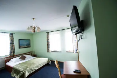 a bedroom with a bed and a tv on the wall at Svečių namai Lingės in Nemėžis
