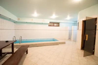 a swimming pool in a room with a table at Svečių namai Lingės in Nemėžis