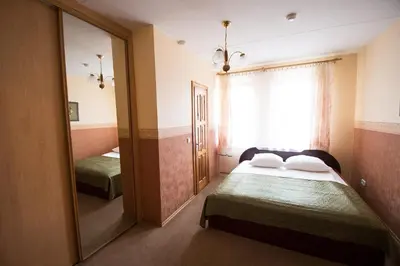a bedroom with two beds and a large mirror at Svečių namai Lingės in Nemėžis