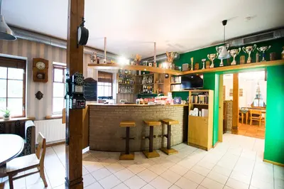 a bar in a restaurant with green walls at Svečių namai Lingės in Nemėžis