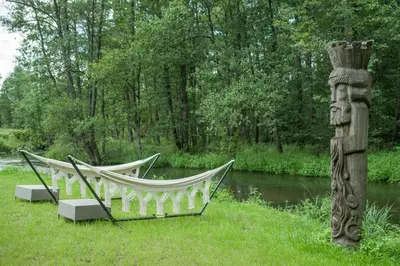 a couple of hammocks sitting in the grass next to a river at Villa Rata in Ratnyčia