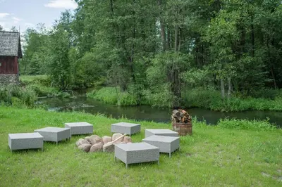 a group of benches in the grass next to a river at Villa Rata in Ratnyčia