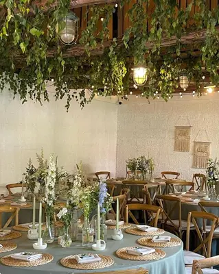 a dining room with tables and chairs with plants at Villa Rata in Ratnyčia