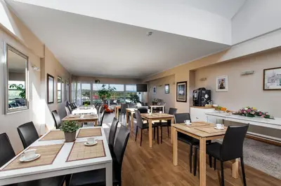 a dining room with wooden tables and chairs at Mineraliniai Apartamentai in Druskininkai