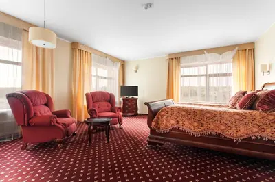 a hotel room with a bed and two chairs at Mineraliniai Apartamentai in Druskininkai