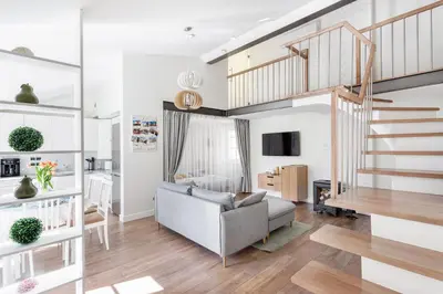 a living room with a couch and a staircase at 3 Bedroom Apartment 24h self check in, free parking, Ac, fireplace in Vilnius