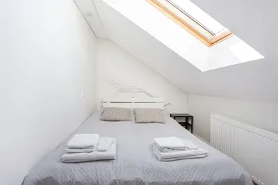 a white bedroom with a bed with towels on it at 3 Bedroom Apartment 24h self check in, free parking, Ac, fireplace in Vilnius