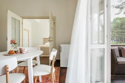 a white table and chairs in a room with a window at Vila''RADIUM'' in Druskininkai