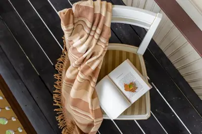 a blanket sitting on a chair with a book at Vila''RADIUM'' in Druskininkai