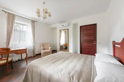 a bedroom with a bed and a desk and a chair at BURMISTRO NAMAS in Druskininkai