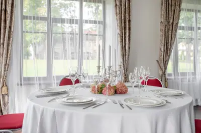 a white table with plates and glasses on it at BURMISTRO NAMAS in Druskininkai