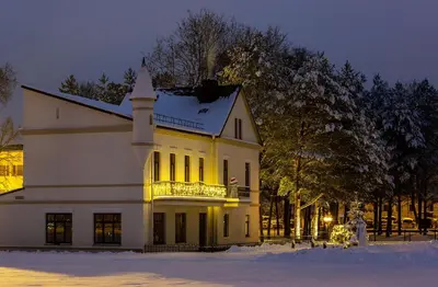 a white house with a balcony in the snow at BURMISTRO NAMAS in Druskininkai