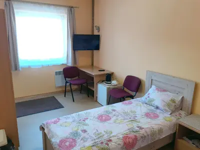 a bedroom with a bed and two chairs and a desk at Kambarių nuoma - Neveronys SAURIDA in Neveronys