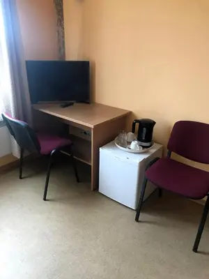 a room with two chairs and a desk with a microwave at Kambarių nuoma - Neveronys SAURIDA in Neveronys