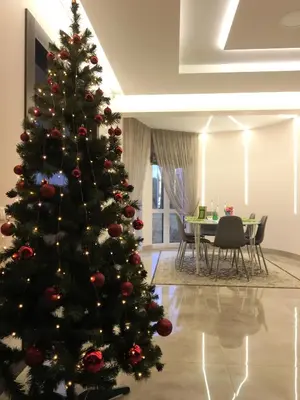 a christmas tree in a living room with a table at Radvi House in Druskininkai