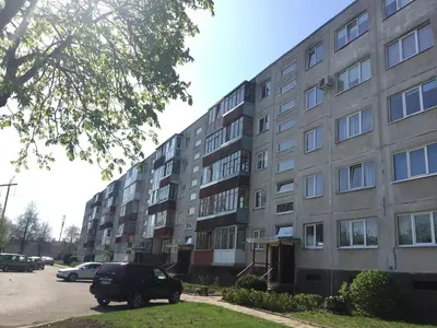 an apartment building with a car parked in front of it at Apartamentai Dainų II in Šiauliai