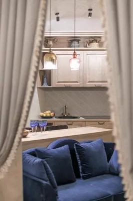 a living room with a blue couch and a kitchen at Luxury apartment in Pilies street in Vilnius