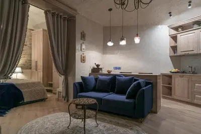 a living room with a blue couch and a bed at Luxury apartment in Pilies street in Vilnius