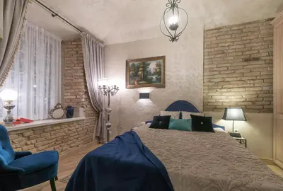 a bedroom with a large bed and a blue chair at Luxury apartment in Pilies street in Vilnius