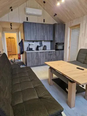 a kitchen and living room with a wooden table at Aido ir Vido sodyba in Utena