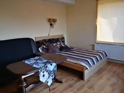 a bedroom with a bed and a table and a chair at Kambario nuoma su bendru vonios kambariu in Kaunas