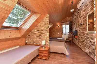 a attic bedroom with two beds and a brick wall at Spa Villa Trakai in Trakai