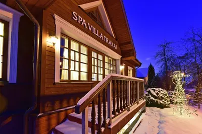 a house with a snow covered porch in the snow at Spa Villa Trakai in Trakai