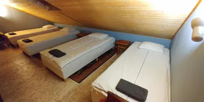 a room with three beds in a attic at Antanelio Sapnas in Pabradė