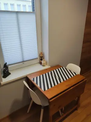 a table and a chair in front of a window at Old Slabada Apartments in Kaunas