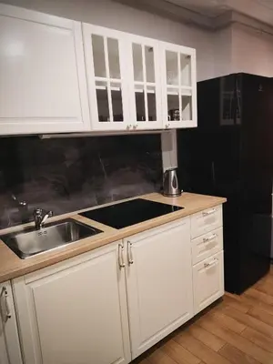 a kitchen with white cabinets and a sink at Old Slabada Apartments in Kaunas