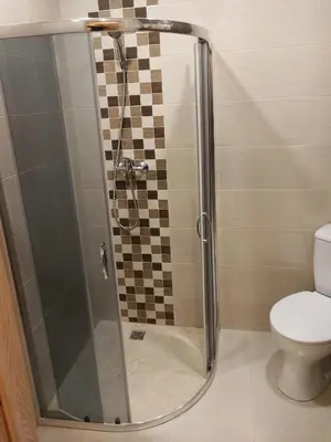 a shower stall in a bathroom with a toilet at Viešbutis Kelyje in Utena