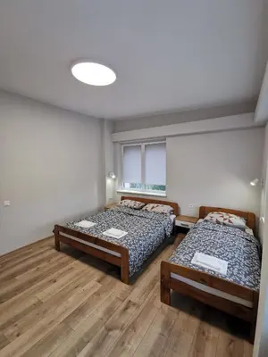 a bedroom with two beds and a window at Viešbutis Kelyje in Utena