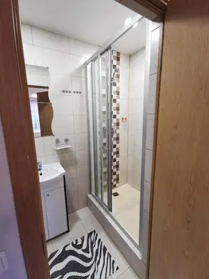 a bathroom with a shower and a sink and a mirror at Viešbutis Kelyje in Utena