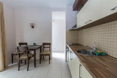 a kitchen with a sink and a table with chairs at Apartments Ameda in Vilnius