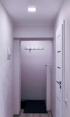a hallway with a white room with a door at Butas miesto centre in Panevėžys