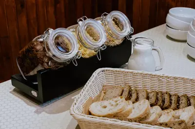 a table with two jars and a basket of bread at Hotel Vita in Druskininkai