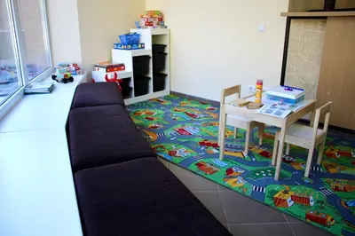a living room with a couch and a table on a rug at Hotel Vita in Druskininkai