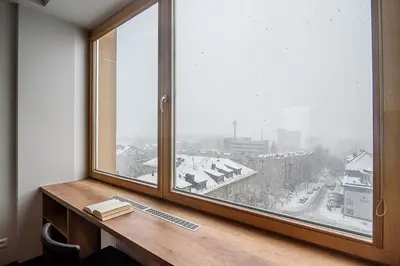 a window with a book on a desk next to it at Apartment with amazing view! in Vilnius