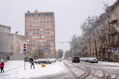 a snow covered city street with people walking in the snow at Apartment with amazing view! in Vilnius