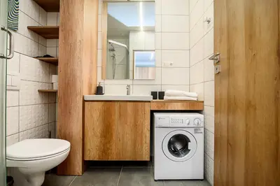 a bathroom with a washing machine and a sink at Apartment with amazing view! in Vilnius