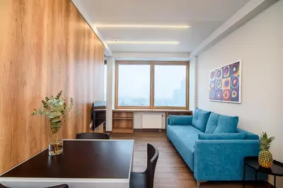 a living room with a blue couch and a table at Apartment with amazing view! in Vilnius