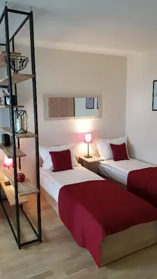a room with two beds and a book shelf at Girelės apartamentai in Kaišiadorys