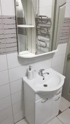 a white bathroom with a sink and a mirror at Girelės apartamentai in Kaišiadorys