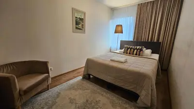 a hotel room with a bed and a chair at Nileja in Vilnius