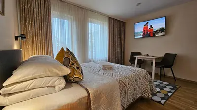 a hotel room with a bed and a tv on the wall at Nileja in Vilnius