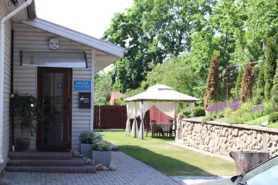 a small building with a table and an umbrella at Nileja in Vilnius