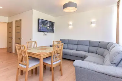 a living room with a table and a couch at Crystal Apartment in Druskininkai