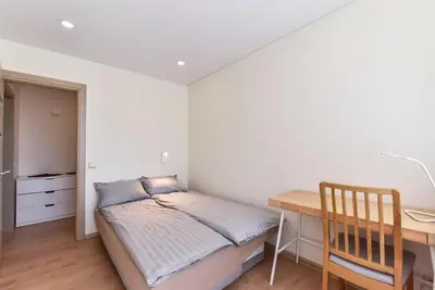 a small bedroom with a bed and a desk at Crystal Apartment in Druskininkai