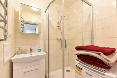 a bathroom with a shower and a sink and a mirror at Crystal Apartment in Druskininkai