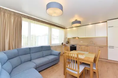 a living room with a blue couch and a table at Crystal Apartment in Druskininkai